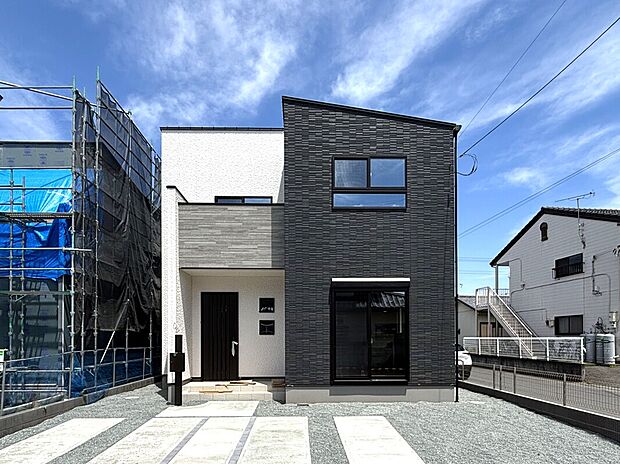 【1号棟　外観】
黒を基調としたモダンなデザインが目を引く外観です！玄関周りには明るいアクセントがあり、帰宅するたびに気持ちが明るくなりますね。