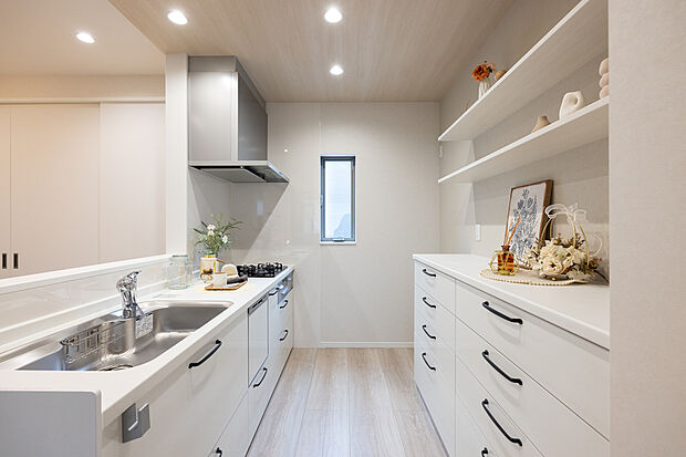 【キッチン/1号地】
ホワイト×木目調で統一されたナチュラルなデザインのキッチンです。調理家電を置いたりと、多用途に活用可能なカップボードが備わっています。食洗機を備え、家事の時短に。