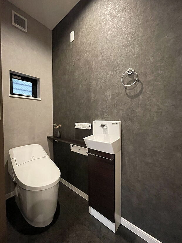 【【当社施工例】トイレ】すっきりとした見た目のタンクレストイレ。温水洗浄便座付きトイレですので、1年を通して快適に使用できます。衛生面に配慮し、手洗い器が備わっています。