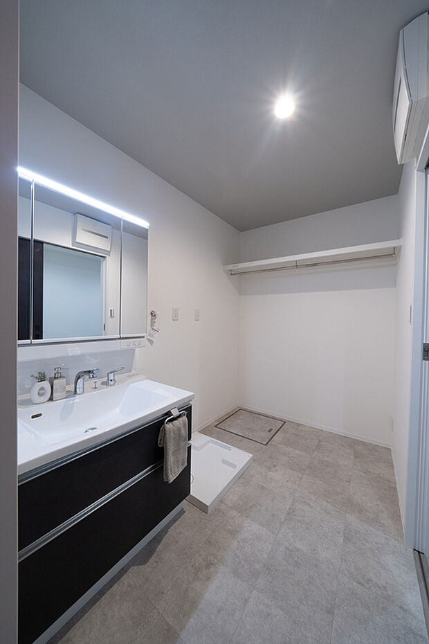 【【サニタリー】】三面鏡付きの洗面化粧台で朝の身支度もスムーズに。洗濯機置き場の横には、棚板とハンガーパイプを設置。収納場所として活用するほか、室内干しスペースとしても便利です。