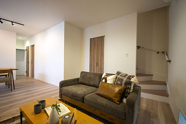 【【1号地・LDK】】ご家族同士で顔を合わせる機会が増える、リビング階段を採用。階段横には、細々とした物も隠して仕舞える扉付きの収納を設けました。