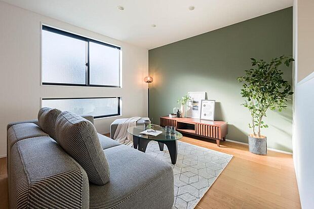 【【LDK/11号地コンセプトハウス】】LDKの壁一面にはグリーンのアクセントクロスを施しており、空間にアクセントを与えています。腰高窓の下にスリット窓を設け、より光が室内に届く設計です。