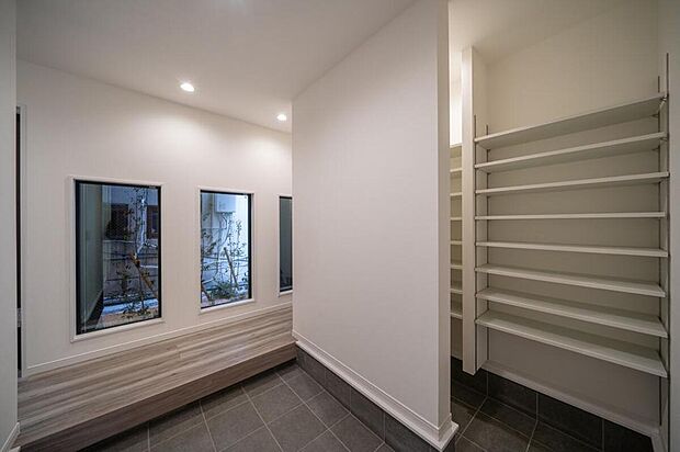 【【本分譲地に建築可能な建物プラン例】】庭の植栽を眺めることができる広々とした玄関は、壁を隔てた空間に可動棚を設置。来客時もすっきり片付きます。《分譲地外:建物面積98.42m2、建物価格1768万円》