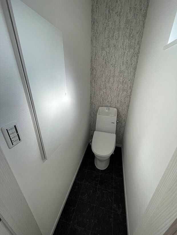 【１階トイレ】壁面収納付きのトイレです。節水タイプで家計に優しいトイレです。（当社施工例）