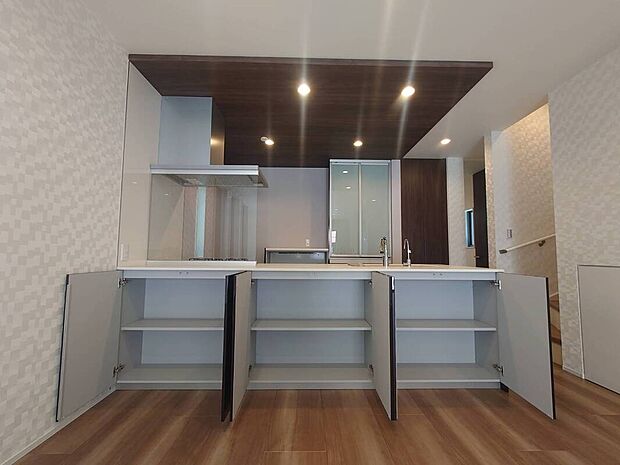 【キッチン】リビング側に便利な収納完備!普段使いのお薬やお子様のおもちゃをすぐ取り出せて便利!キッチン上部は折下天井を採用、高級感あふれるデザイン、お洒落で機能的な空間を実現します!