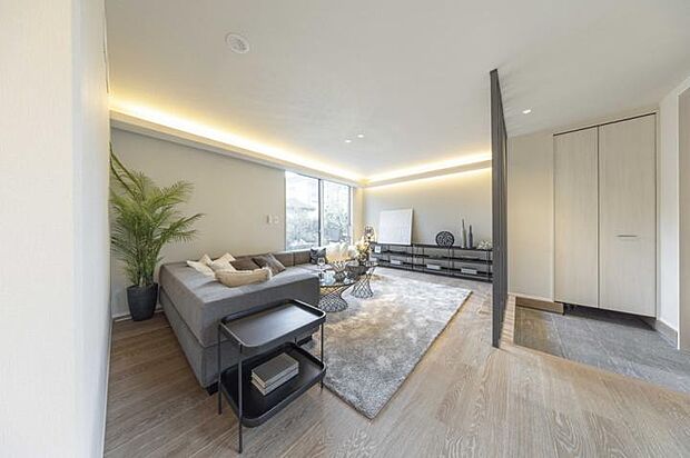 【No.6_LDK1(撮影_2025年9月)】天井や壁に光を反射させる間接照明をベースに、空間をより広く高く見せ、柔らかな光が包み込む落ち着いた雰囲気を演出します。