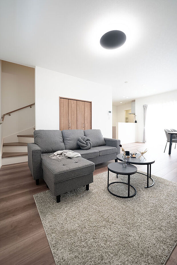 【【1階約19.8帖LDK/A号地】】LDK全体は木目のフロアや建具によりナチュラルな印象です。リビング階段下スペースは収納となっているため、ブランケットなどのご家族共用品がスッキリと収まります。