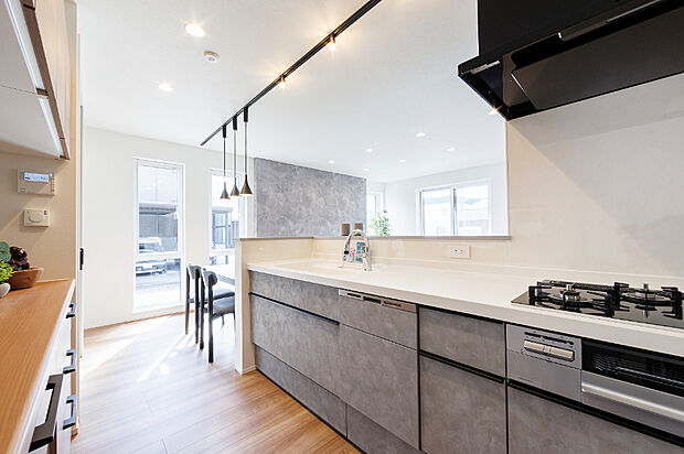 【【2号棟/キッチン】】シンプルながら洗練されたモダンスタイルの対面キッチン。家事をしながらも家族との会話や時間を楽しめる空間となっています。(2026年3月撮影)