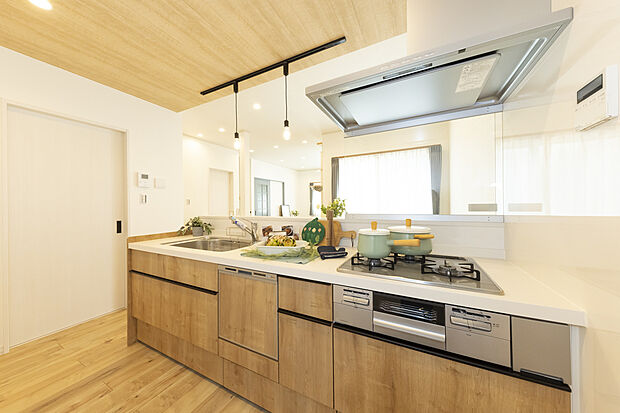 【2号地/キッチン】
明るく開放感のある対面式システムキッチン。床材と合わせた木目のキッチンパネルを採用し、統一感を高めています。