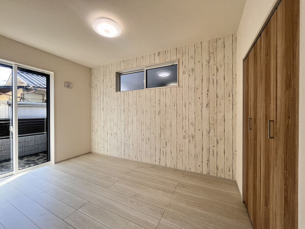 【2号棟】1階洋室D5.0帖（2026年3月21日撮影）　LDKから続く居室。赤ちゃんのお昼寝やお子さんの遊び場にぴったり。南側と西側に窓のある、明るい日差しが心地よいスペースです