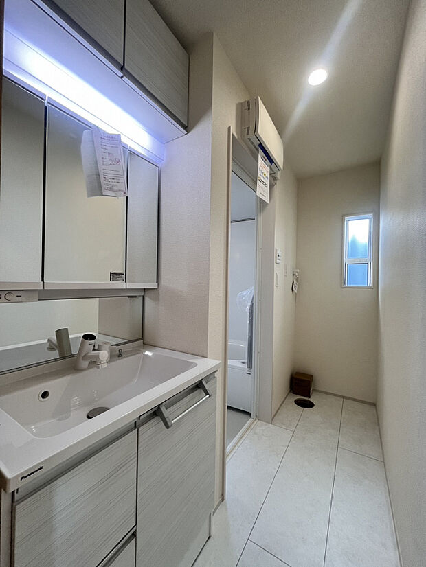 【【2号棟】洗面所（2026年3月21日撮影）】洗面室には、三面鏡付きで幅約90センチのワイド仕様の洗面化粧台を標準装備。