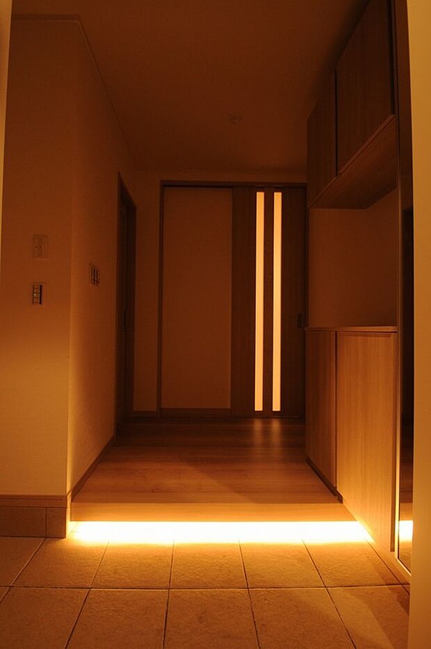 【玄関間接照明】夜間の帰宅時には玄関の人感センサーにより玄関框の間接照明がホッとするような和らかい光でお出迎え。