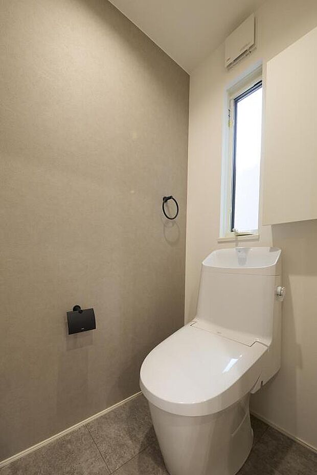 【トイレ】トイレは白とライトグレーでまとめあげたホッと落ち着く空間。余計な収納部分を排したことで空間に余白を生み出しました。窓は採光と共に通気も兼ねており清潔感溢れる空間を演出します。