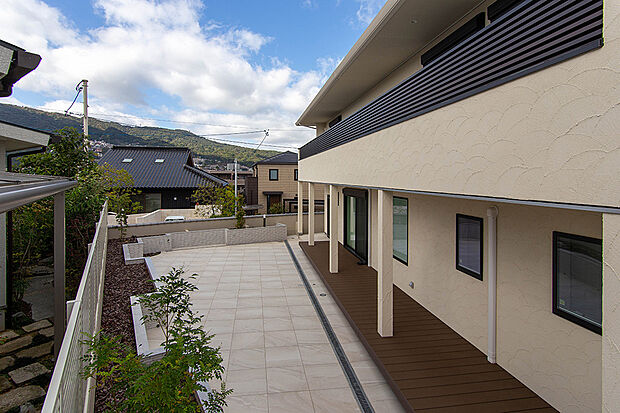 B号地現地施工例。（2024年11月）撮影
エレガントな照明付きの生垣があるタイル貼りのテラスには南からの日当たりが良好なウッドデッキを設けています。