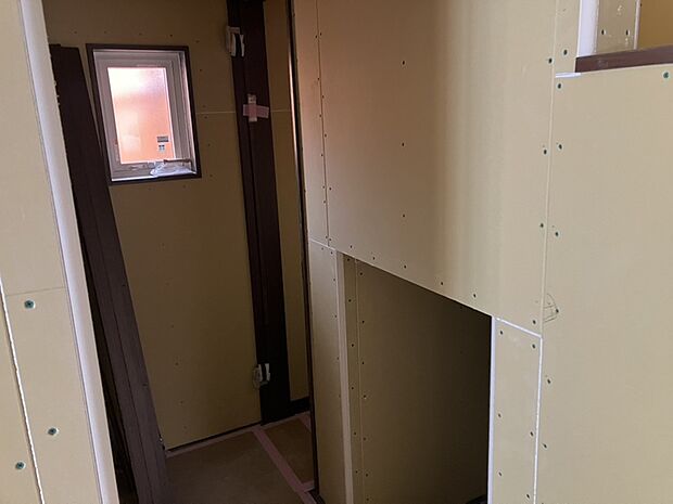 【【廊下】】LDKからトイレへ向かう廊下にはコミュニケーションブリッジの下の空間を利用した収納があります。洗面台・トイレが近いので日用品のストックの保管に便利です。/2026.2.8撮影