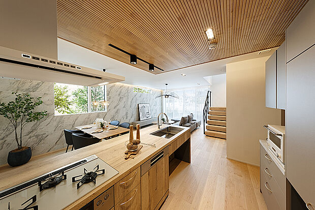 【【近くの分譲地で公開中のモデルハウス／LDK】】天板が木目調の珍しいキッチン。見た目だけじゃなく使い心地にもこだわり、広々としたスペースを演出しました。
住環境も利便性も兼ね備えた、アクティブライフを叶えた地。