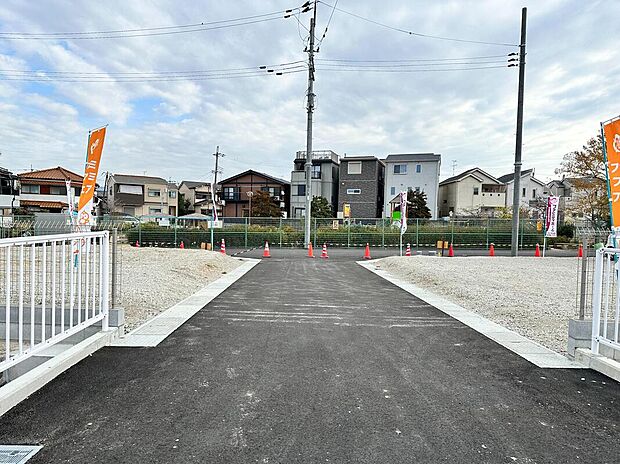 【【前面道路を含む現地写真】】街区内の道路は、アスファルト舗装済み。道路と敷地の高低差がほとんど無く、車の入出庫や、ベビーカーや自転車での移動もスムーズに行えそうです。/2024年12月撮影