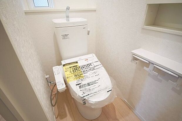 【トイレ】温水洗浄機能を備えたトイレ、白を基調とした清潔感ある空間