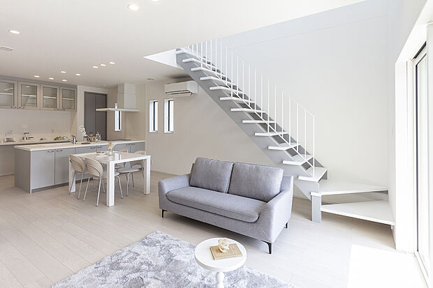 【【1階約18帖LDK/A号地モデルハウス】】吹抜やオープン階段による心地よい光や風に包まれるLDKで寛ぎの時間をご家族とともに。キッチン、ダイニング、リビングのどこにいても視界が抜け、上階とゆるやかにつながる開放感に満たされます。