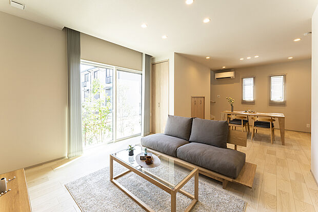 【【1階約20帖LDK/A号地モデルハウス】】生活のメインスペースとなるLDKは約20帖の広さがあり、コミュニケーシンを育むリビング階段仕様。木目をふんだんにあしらったナチュラルな空間で、ご家族団らんの時間をゆったりとお過ごしいただけます。