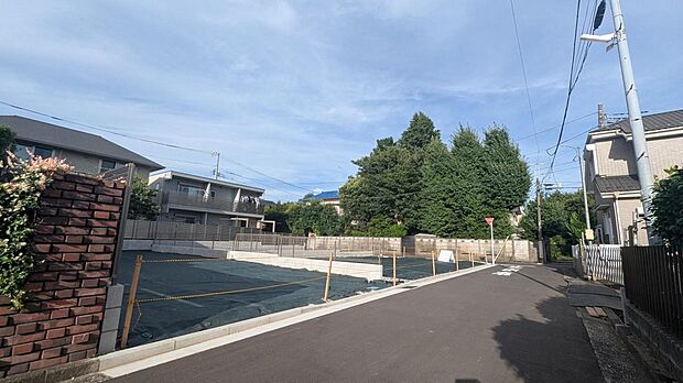 【前面道路含む現地写真】現地前面道路から望む、緑豊かで落ち着いた街並み。低層住宅が並び、空の広がりを感じられる住環境です。