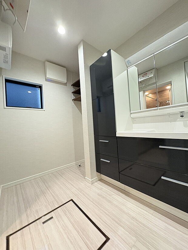 【洗面所】
ゆとりある広さの洗面所。洗濯機置き場の上部には、可動棚が設置されています。洗面化粧台は水栓周りに水が溜まりにくい上方吐水タイプです。