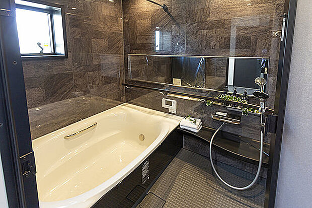 【【当社施工例】】石目調のアクセントパネルを施した、高級感のある浴室。ゆったりとした浴槽を備えており、足を延ばして一日の疲れを癒していただけます。お子様と入浴される際にもゆとりがあります。窓付きで自然換気も可能です。