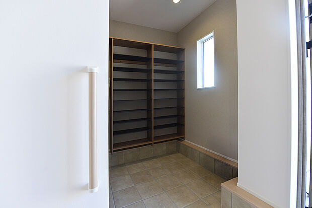 【【1階玄関/F号地モデルハウス】】大容量の土間収納を設け、上がり框にゆとりがあるエントランス。土間収納は靴のままで出入りができ、アウトドア用品や靴、お子様の外遊びのおもちゃなどがすっきりと収まります。