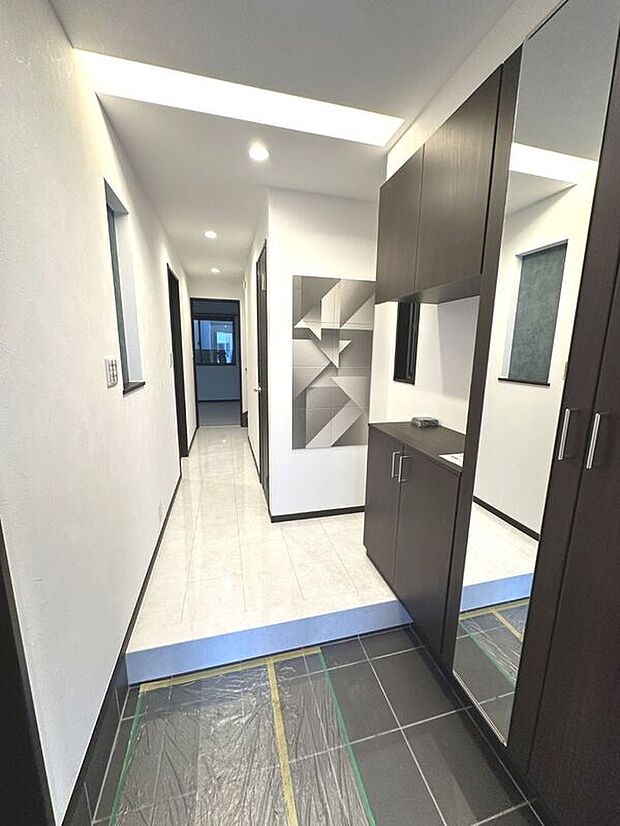 【玄関【アーバンポート施工例】】御家族皆様の「いってきます」「ただいま」の声がこだまする、清潔感溢れる玄関スペースにもエコカラットを配置。姿見付きの大容量シューズボックスがありますのでいつ来客が来てもスッキリとした空間に。