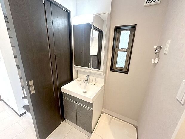 【洗面化粧台】大きな三面鏡と併せてリネン類等、たっぷりしまえる収納力を備えています。【A号棟　2025年7月撮影】