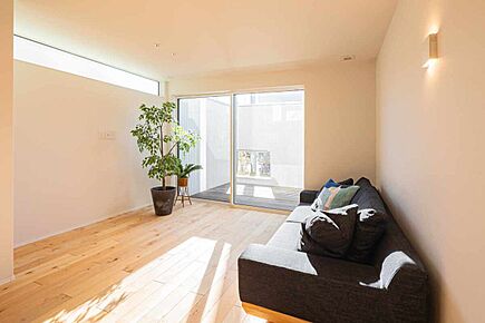 日当たりの良いリビング。通常より横幅の広い窓そ採用しており、BBQの準備など、キッチンから物が運びやすいです。また、白い塀が外からの視線を遮るので安心してお過ごしいただけます。 