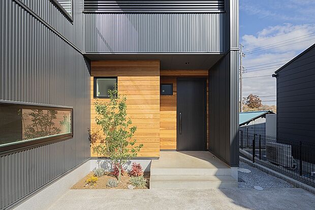 【2号棟（ASOBUとMANABU）イメージ】ブラックにレッドシダーの木目が映え、明るい玄関を演出。