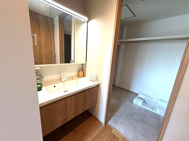 【Panasonic洗面【シーライン】】【5号地洗面台】Panasonic洗面ドレッシング「シーライン」オーク柄採用。使いやすく、シャワーヘッドは引き出せてお手入れも楽なデザイン。ヒーターレスで曇りにくい「くもりシャット！」で電気代もかからずお風呂上りも鏡はいつもクリア。脱衣所と扉で仕切られています。