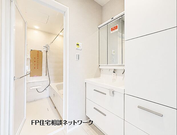 【洗面台・洗面所】白を基調とした清潔感あふれる明るい洗面脱衣室です。三面鏡裏や足元の引き出しなど豊富な収納を備えた洗面台を採用しており、小物やタオル類もすっきりと整理できる機能的な空間です。
