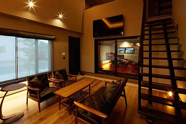 【インダストリアルな雰囲気のLDK】木目の勾配天井で開放感溢れるリビング。
生活感を出さないよう天井部分には照明を入れず、間接照明をふんだんに使用しています。(建築実例より)