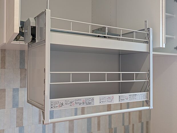 【キッチンダウンウォール収納】手が届きにくい高い位置の棚を、手動で目の高さまで降ろすことができて、出し入れがラクラク。棚がほぼ一定の速さで降りてくる「定速度ダンパー」と、スムーズに上げ下ろしができる「荷重切替機能」が付いています。