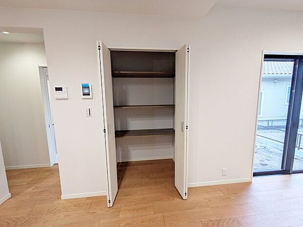 【収納】【扉付き収納】 リビングには、日用品や掃除用具などをスッキリ収納できる扉付きの収納スペースを設けています。 見た目をすっきり保ちながら、生活感が出やすいアイテムも隠せるので、来客時も安心です。