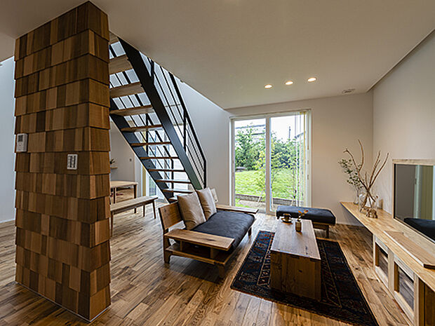 【プラン例】
階段が見せ場の伸びやかなLDK。階段によって適度な囲まれ感が出た、落ち着きのあるリビング。窓の外には共有の緑地が見える。