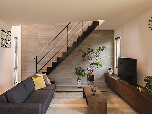 【プラン例】
リビングでは吹き抜けの壁にも床と同材の天然石を掘り上げ、スチール階段が見せ場のひとつに。光と影のバランスを操作して、豊かな空間を演出しています。