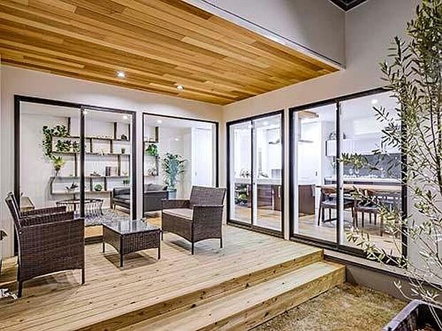 【【プラン例】】中庭にセカンドリビングとして存在するデッキにはステップを設けた。軒天にも木をあしらいダウンライトで演出。