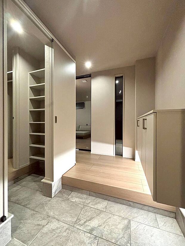 【玄関】6号地モデルハウス LDKの入り口には、YKK APの『ファミットG』を採用。天井まで届くハイドアとガラス戸がもたらす圧倒的な開放感を、ぜひ現地でご体感ください。