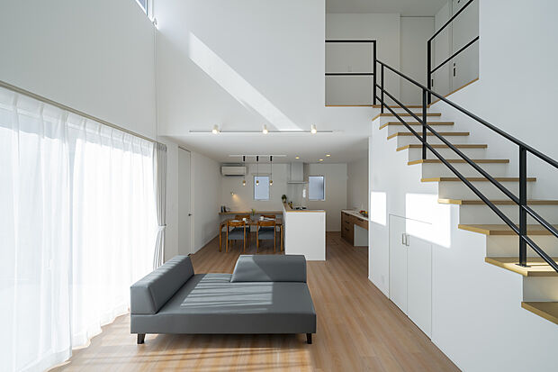 吹き抜けから光が降り注ぐ開放的なリビング