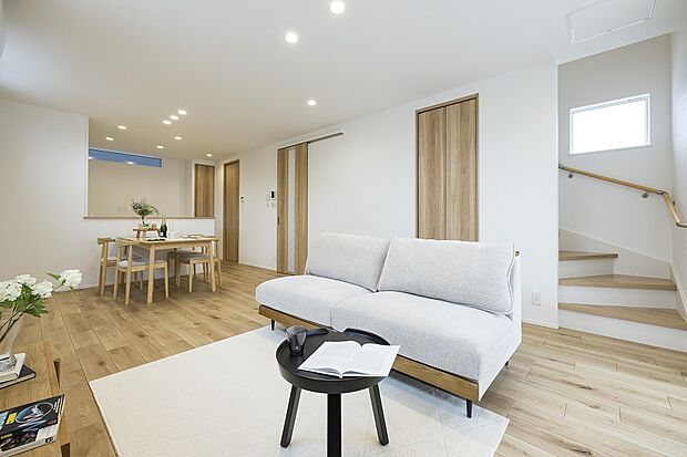 【1階約17.83帖LDK/1号地モデルハウス】リビングアクセス階段を採用し、ご家族のコミュニケーションが円滑に。対面キッチンから視界が開け、一体感に包まれます。収納を備え、リビング周りが片付きます。