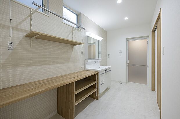 【1階洗面所・ランドリースペース/1号地モデルハウス】玄関~水回り~LDKが回遊でき、帰宅時の手洗いや家事効率UP!室内物干を備え、洗濯物を「洗う→干す」が短く効率的です。カウンターはアイロン掛けな