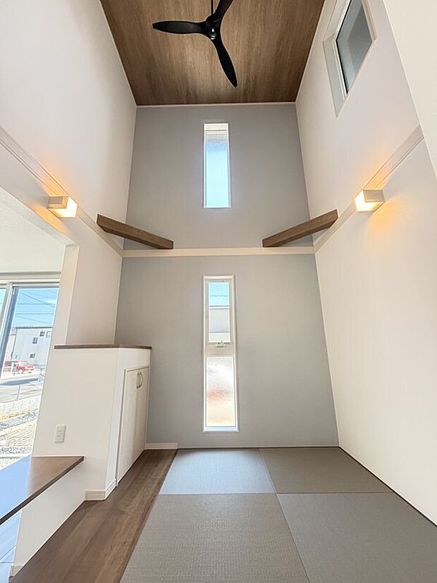 【【2号棟:畳コーナー】】開放感あふれる吹き抜けとやさしい光が差し込む、上質なくつろぎの畳コーナー。家族の団らんはもちろん、お子さまのお昼寝スペースとしても活躍する、癒しに満ちた空間です。