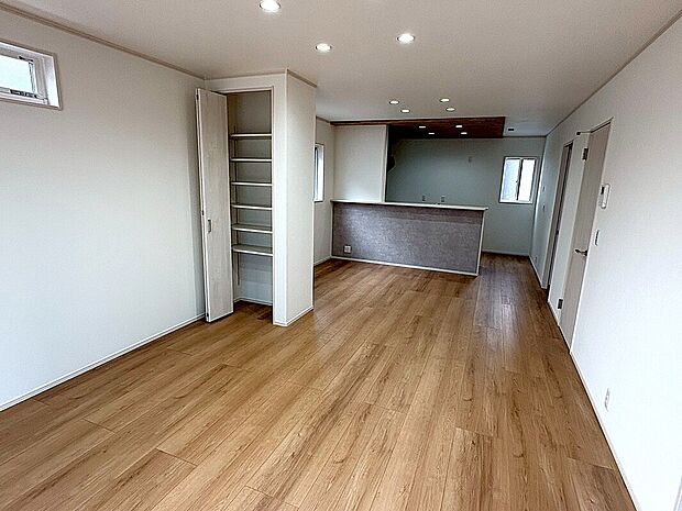 【8号棟 LDK】奥行きのある広々としたLDK。小物の整理に便利な可動棚付きの収納や、グレーのシックなキッチンカウンターがスマートな暮らしを演出します。
