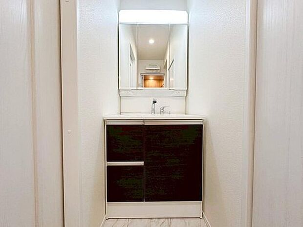 【洗面台・洗面所】白を基調とした爽やかなサニタリースペース。収納たっぷりの三面鏡に陽の光差し込む明るい空間で、毎日の身支度も気持ち良くお使い頂けます。