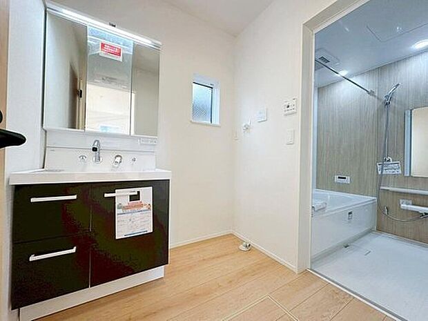 【洗面台・洗面所】白を基調とした爽やかなサニタリースペース。収納たっぷりの三面鏡に陽の光差し込む明るい空間で、毎日の身支度も気持ち良くお使い頂けます。

