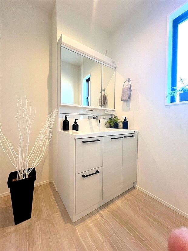 【施工例】収納力を備えた三面鏡洗面化粧台を採用。日用品のストックまですっきり収納！ 爽やかに気持ちよく1日が始められるように、美しい洗面化粧台をご用意しました。
