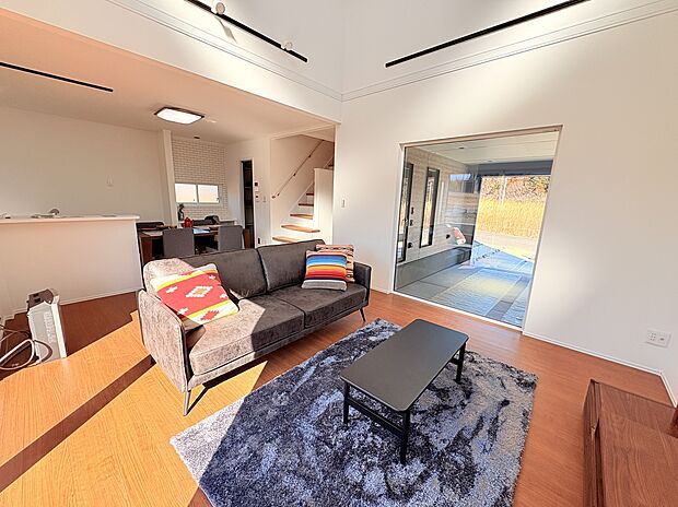 リビングの大きな窓から愛車を眺める、贅沢なガレージライフ。吹き抜けによる開放感と明るい陽射しが心地よいLDKです。暮らしの中心に趣味を感じる、ここならではの住空間をご提案。